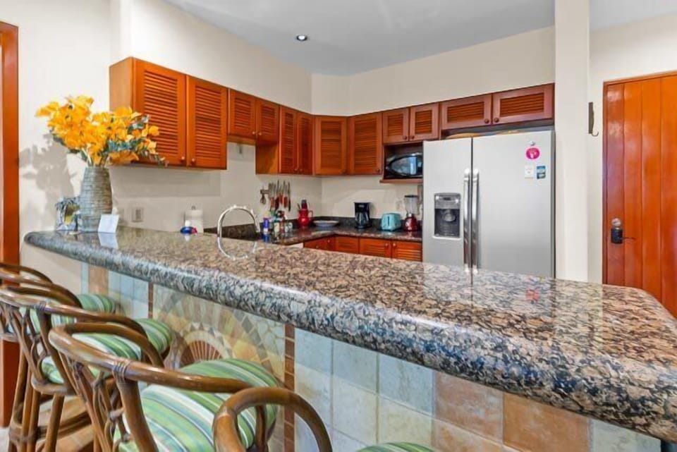 Kitchen is fully equipped with small and large appliances and breakfast counter