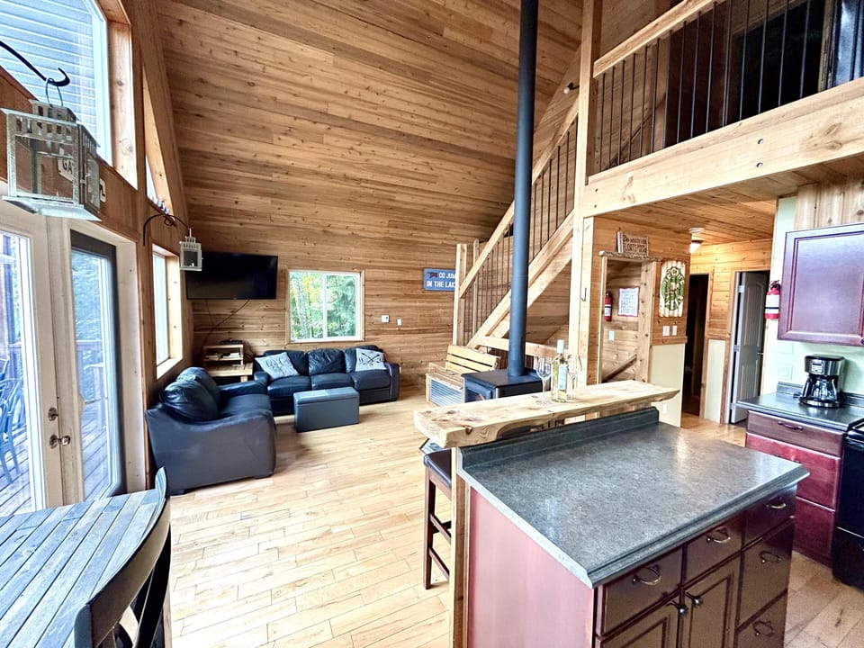 Spacious open-concept living area with vaulted ceilings and natural light