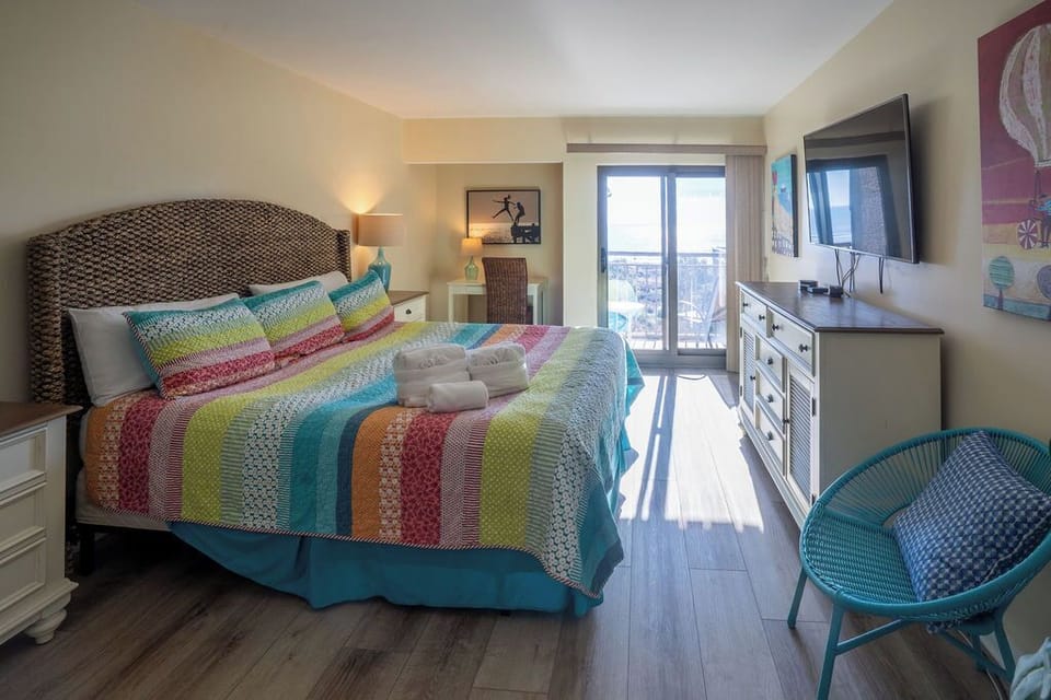 Primary ocean-facing bedroom with view of balcony