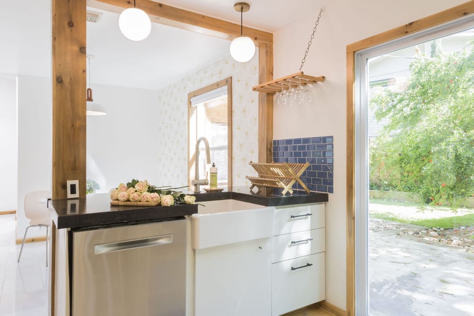 Looking from kitchen into dining nook, farmhouse sink and Bosch dishwasher