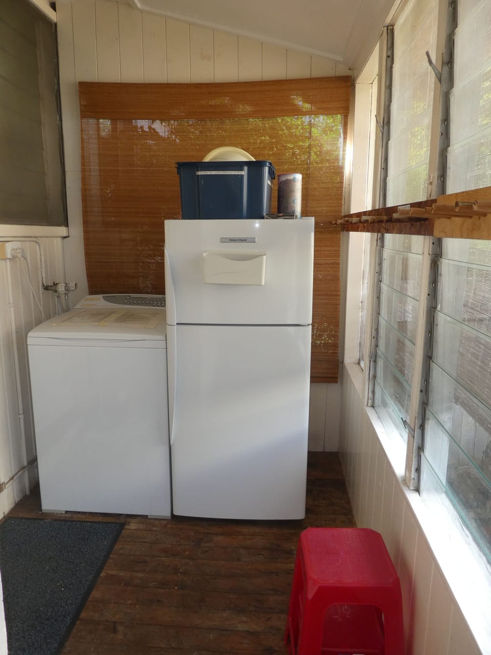 Rear porch with washing machine, second refrigerator, ski and fishing rod racks