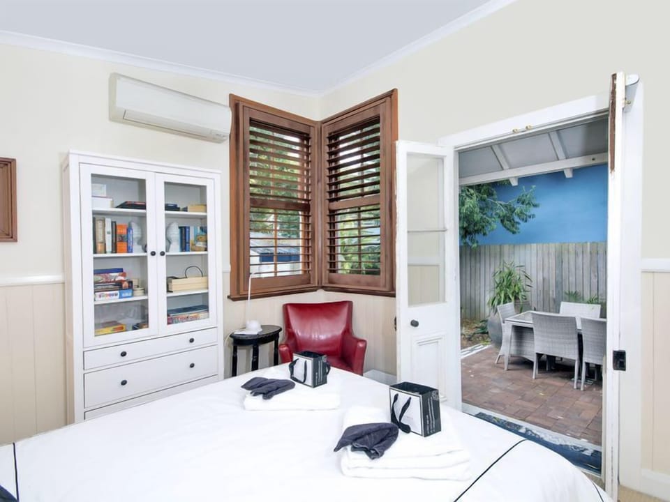 The fourth bedroom opens through french doors to the private backyard.