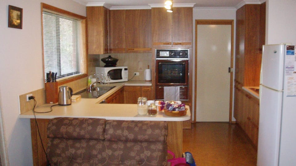 Kitchen showing bench, sink, microwave, wall oven, cooktop and Fridge