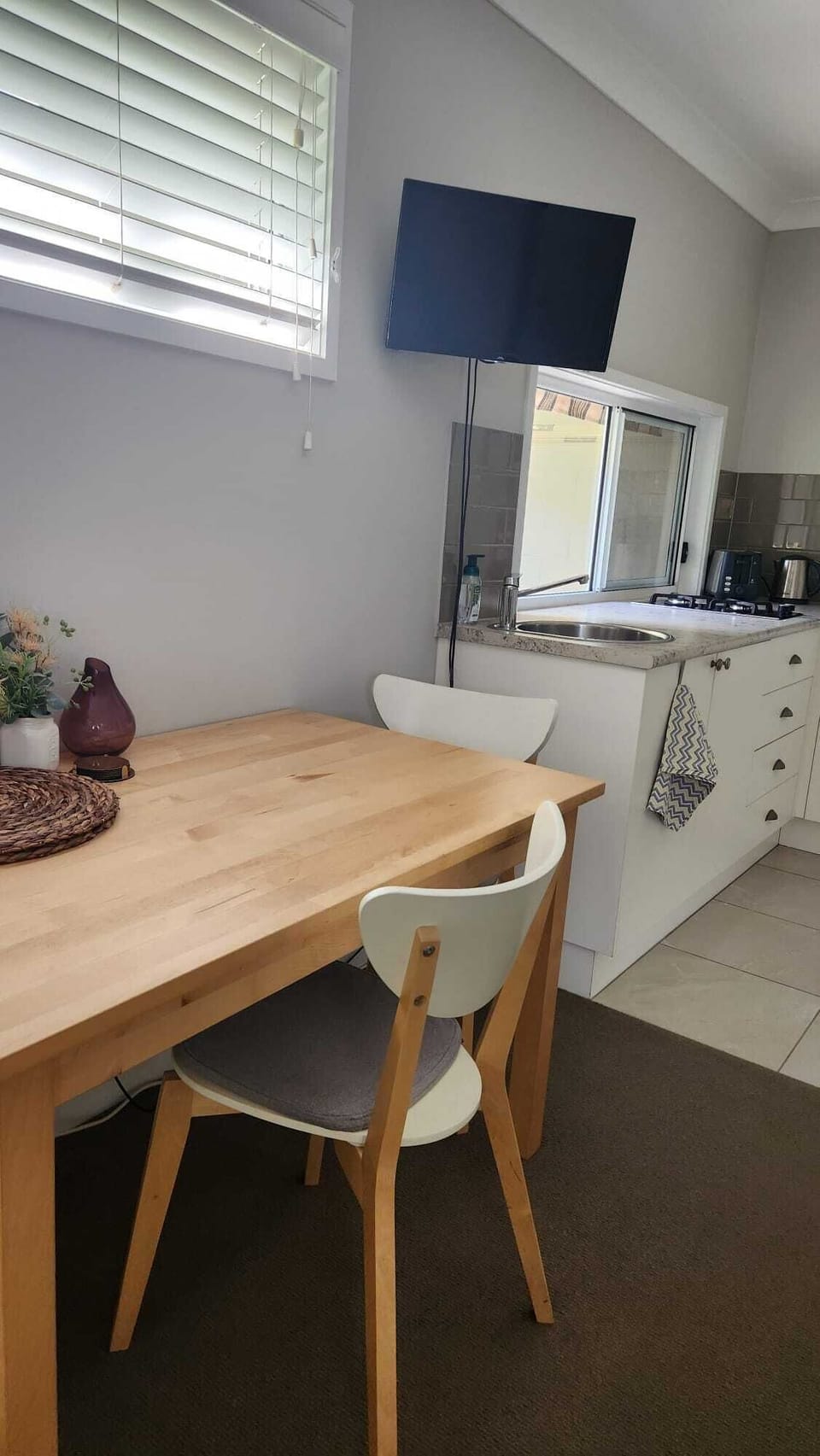 Dining table with chairs next to kitchenette