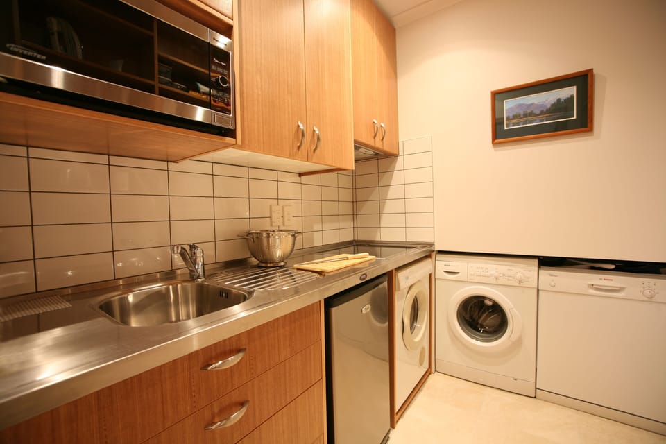Kitchen Area - The kitchen area is located off the second bedroom / second dining room. It is compact in size and includes a small fridge,  dishwasher, washing machine and separate dryer. A small freezer is located in the hall cupboard. 