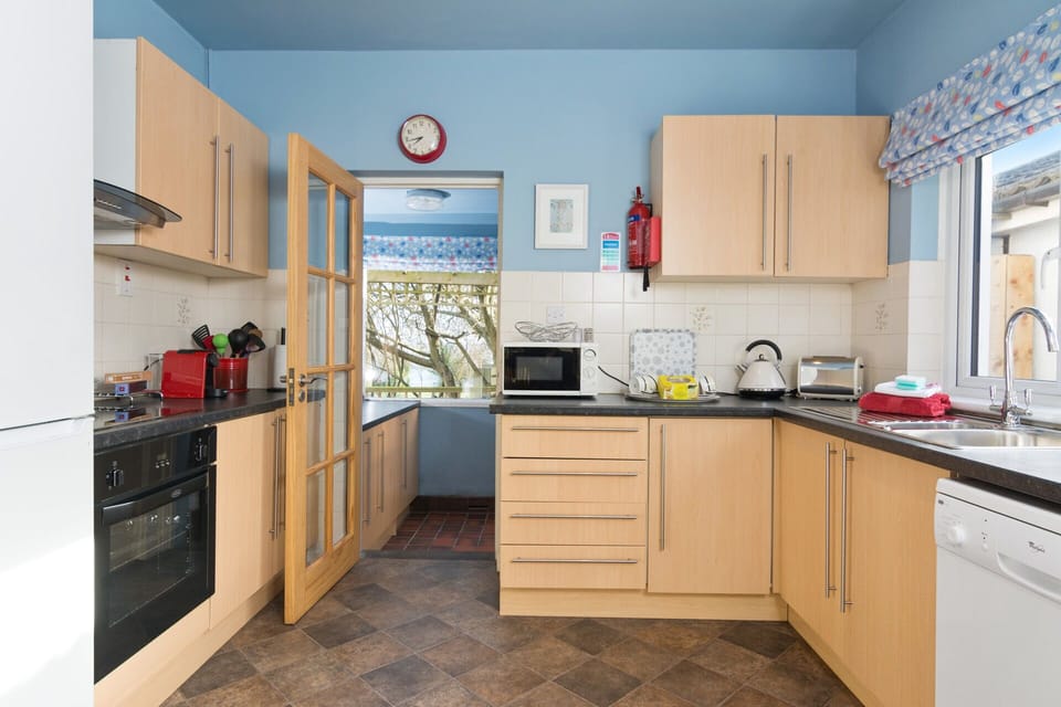 Kitchen with luxury 'white' goods including  dishwasher.  Laundry Room beyond.