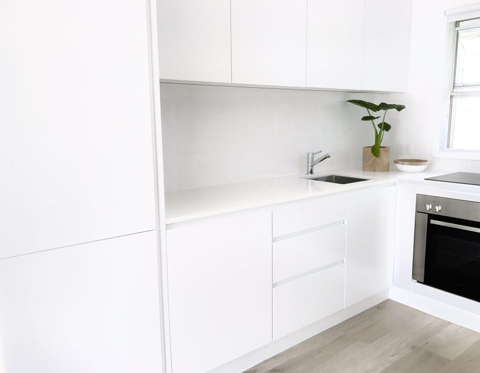 All white kitchen with integrated appliances.