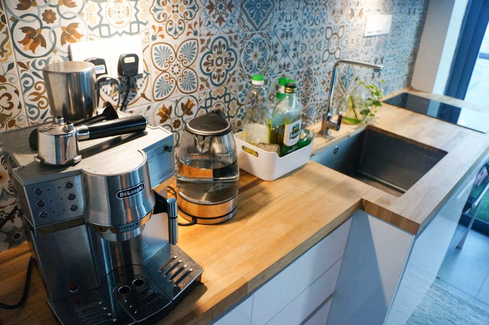 Kitchen with coffee machine, kettle, microwave, fridge, induction hob, condiment
