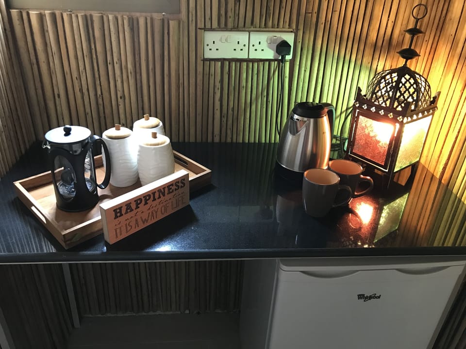 Kitchenette with fridge, kettle, coffee maker and supplies 