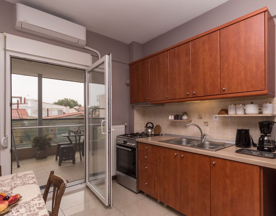 Fully equipped kitchen. Door to a huge balcony with table chairs and swings  