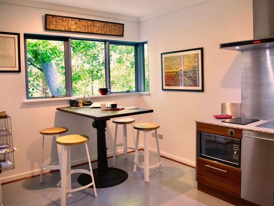 The trendy industrial kitchen has a view straight out into the tree top