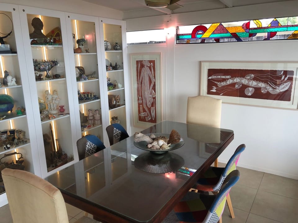 Indoor dining with wall cabinet & bifold doors leading to outdoor dining & BBQ. 