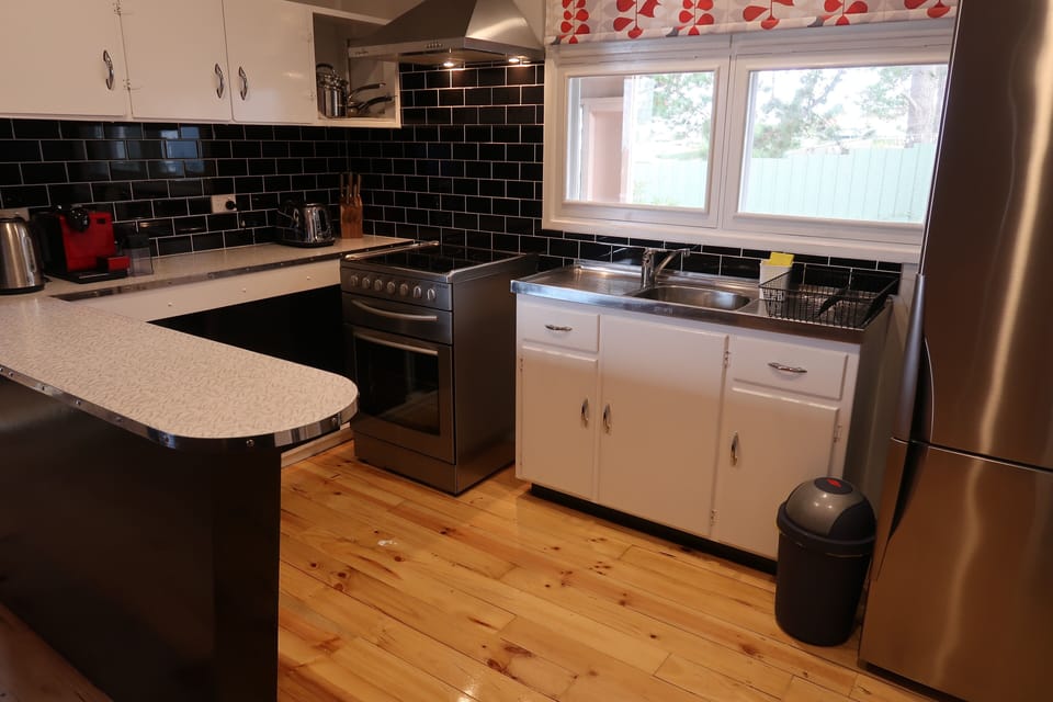 Fully equipped kitchen including oven, cooktop, microwave, and Nespresso machine