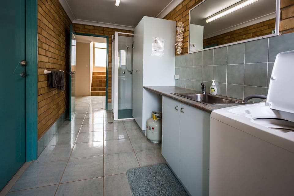 laundry with dryer, washing machine, detergent, ironing board, iron, brooms ...