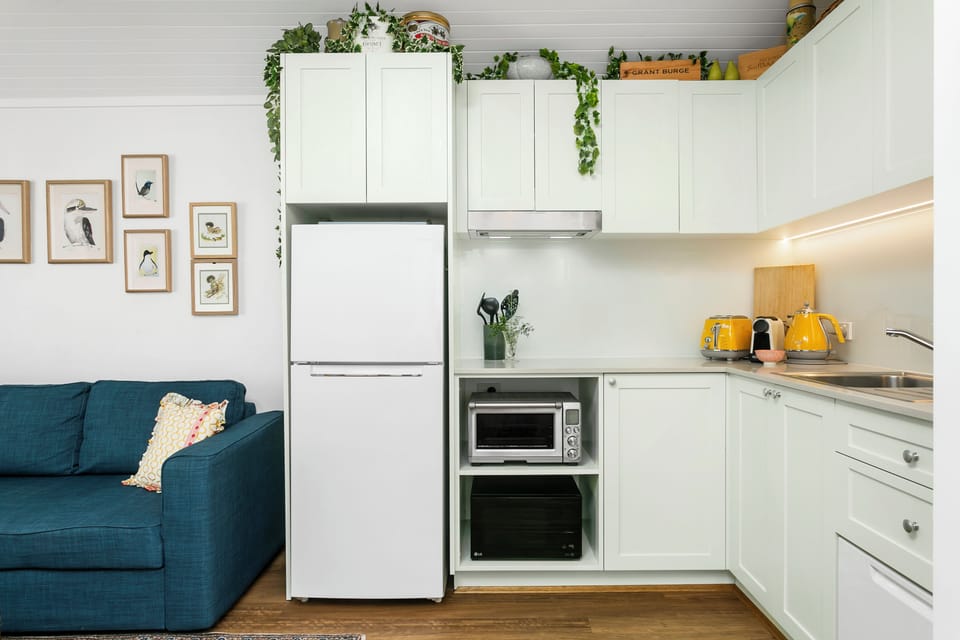 Kitchen side view, fridge, freezer, pots pans and crockery provided. 