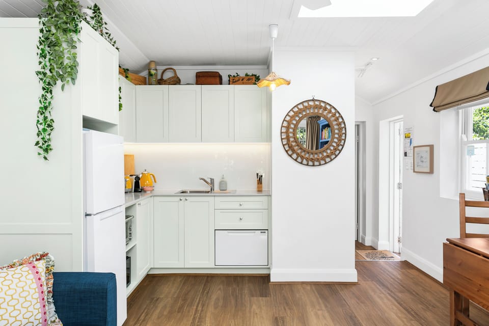 Kitchenette with dishwasher, microwave, benchtop oven, induction hot plates. 