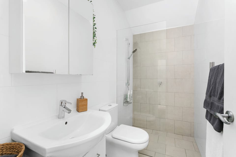 Bathroom with walk in shower, ceiling fan, heat lamps, heated towel rail. 