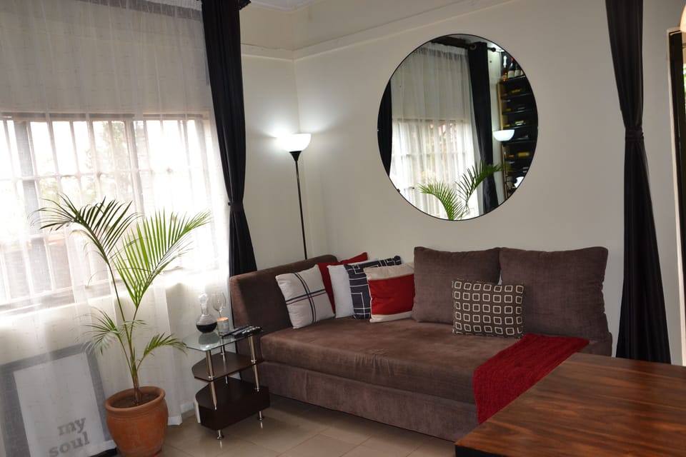 Round mirrior above the sofa that reflects light from the window