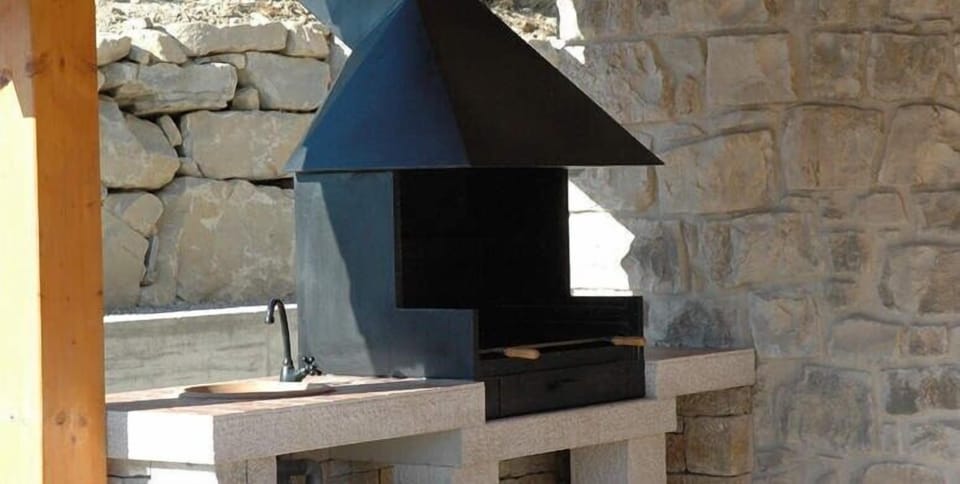 There is an outdoor kitchen with BBQ area