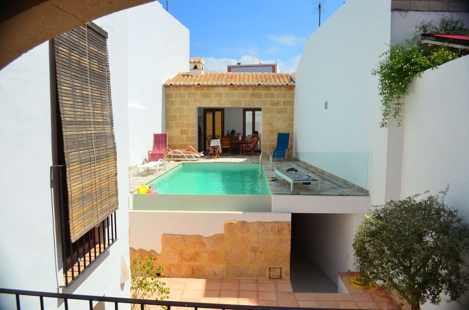 View from the kitchen terrace - pool and outdoor dining area with pizza oven