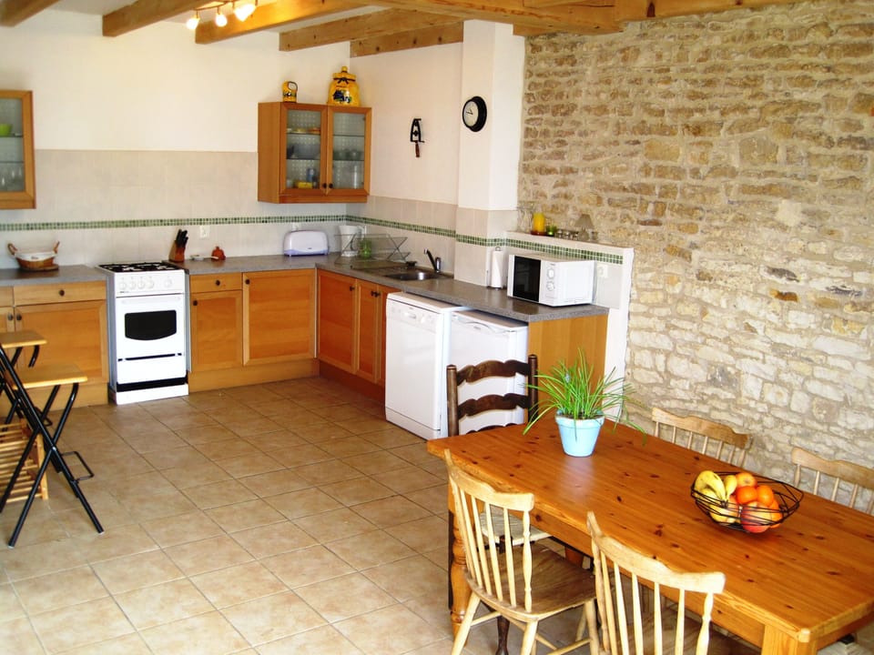 Open plan fully fitted kitchen and dining area at Le Noisetier