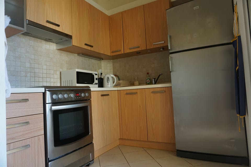kitchen with door to the covered balcony with table and seats for 6 persons.