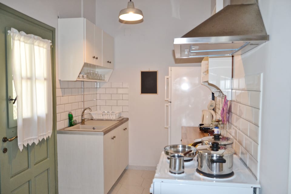 Kefalonia 2 bedroom apartment: kitchen with sink, stove, oven, dining table