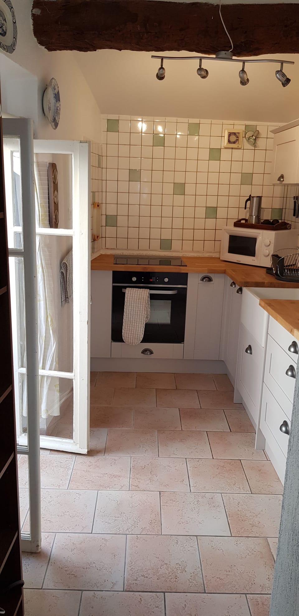 A fully equiped kitchen with fridge/freezer and doors onto a small balcony. 