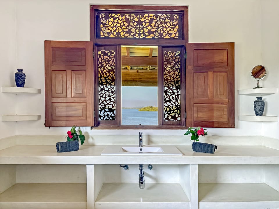 Enjoy the view from the bathroom through the ornate, antique window.