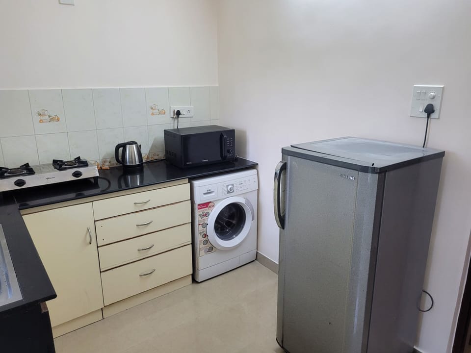 Kitchen has key appliances including fridge, microwave, washing machine, etc.