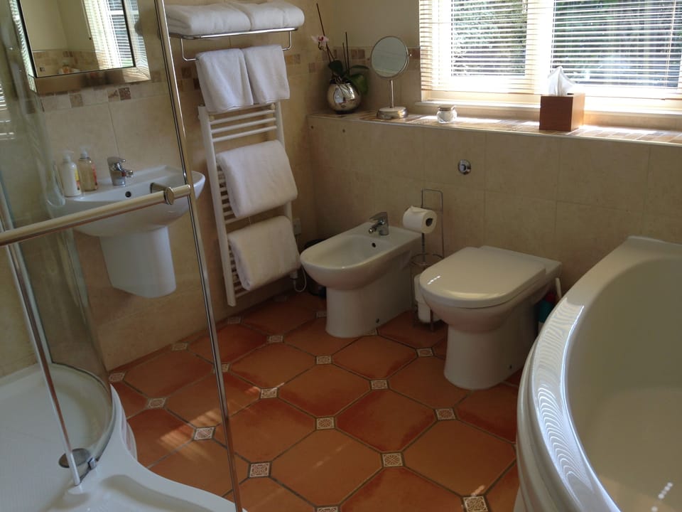 Large family bathroom with walk in shower and corner bath.