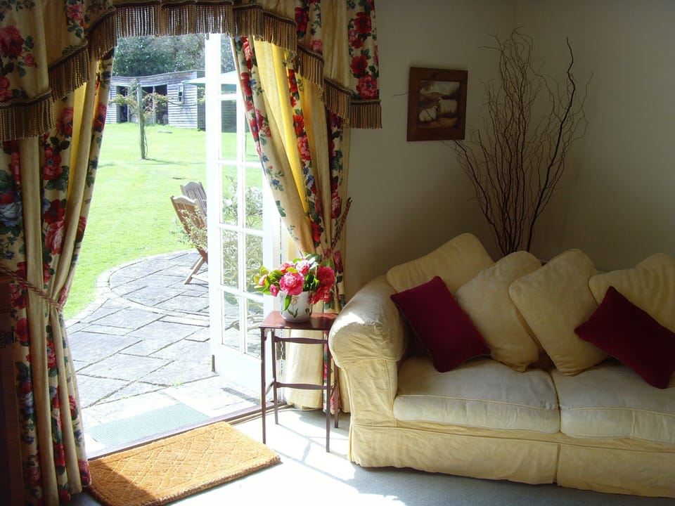 Dairy cottage lounge with french doors onto patio and gardens