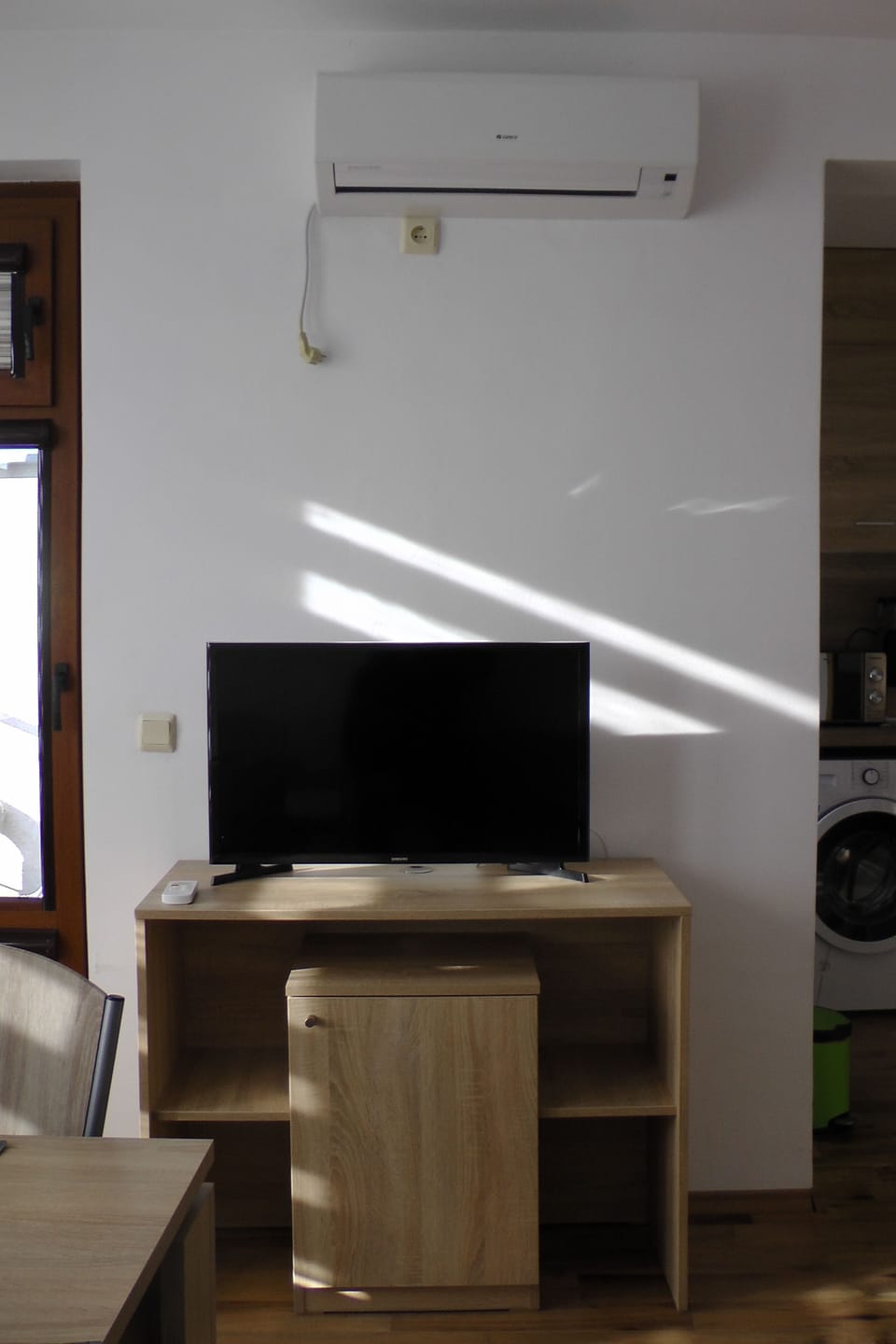 Tv , air conditioner  and terrace door on the left in the living room  