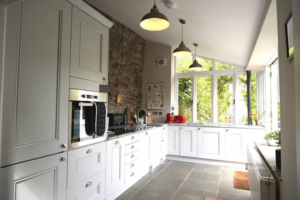The open-plan kitchen with exposed brick wall looking out onto the private courtyard.