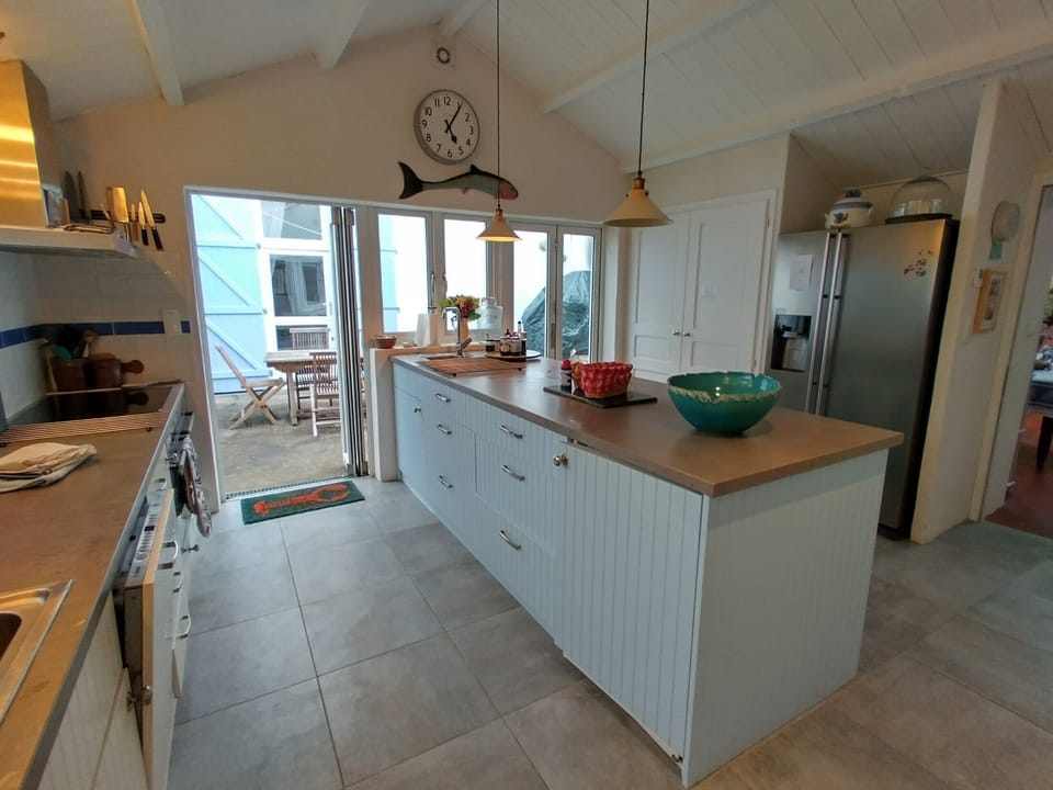 Kitchen showing outside eating area and BBQ under tarpaulin