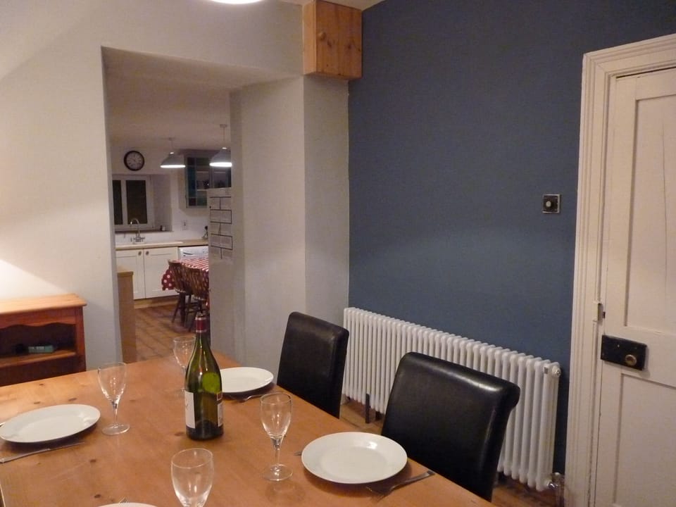 The dining area, with the open plan kitchen behind, and vibrant lighting.
