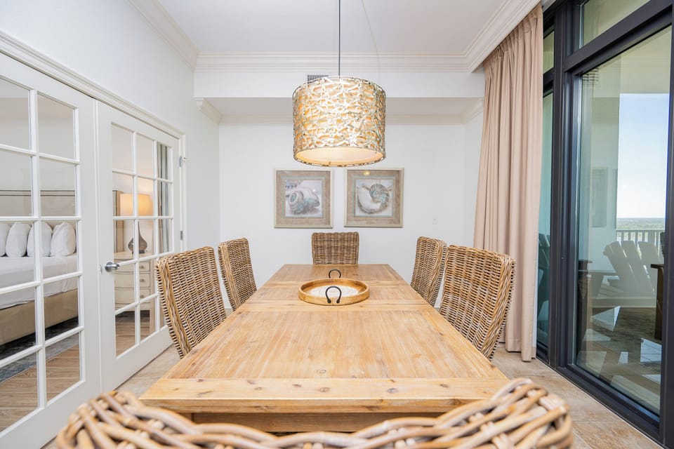 This dining area features a rustic wooden table and chairs, perfect for enjoying meals overlooking a serene area