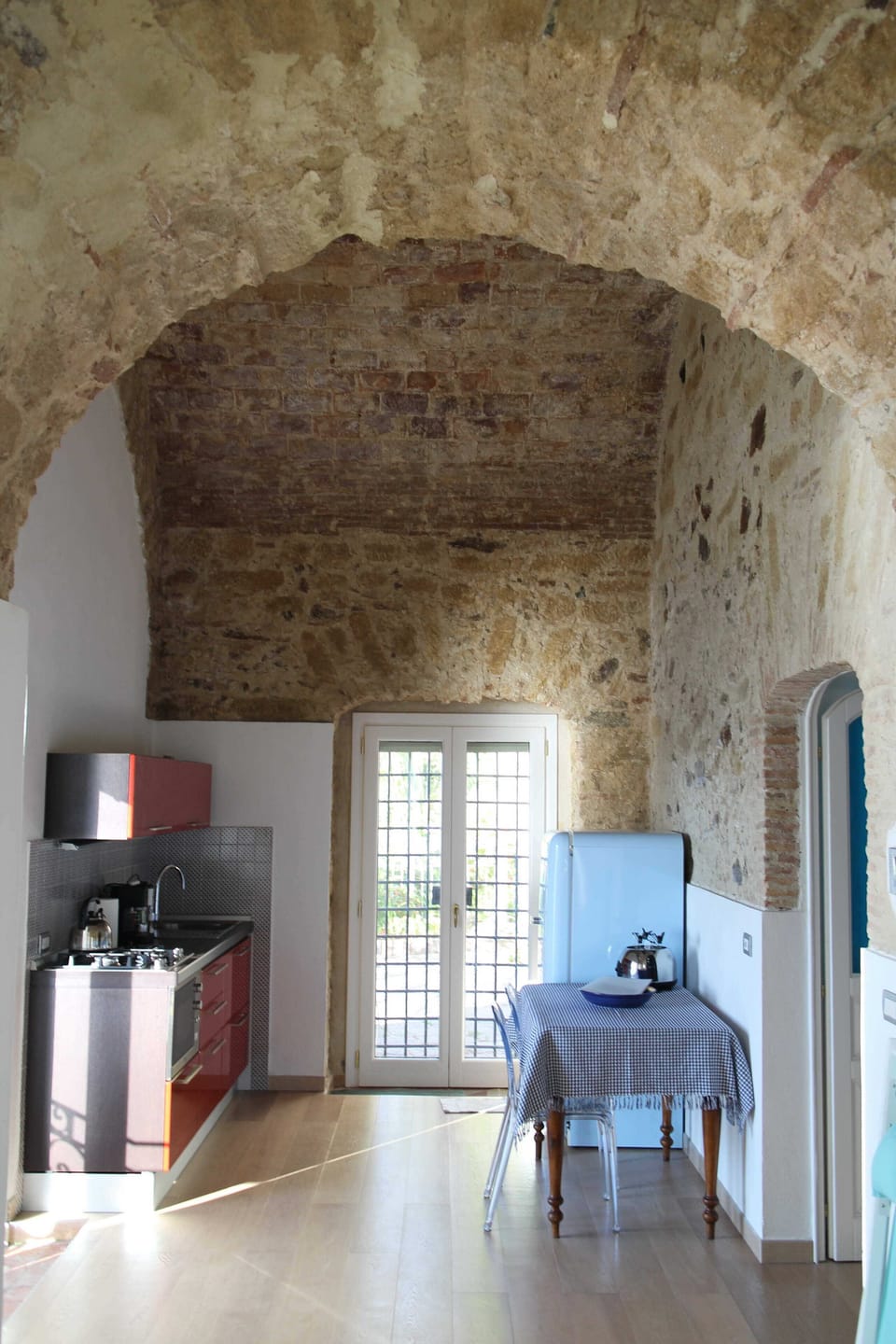 vaulted ceiling, kitchen corner, fridge, dining table and garden terrace access