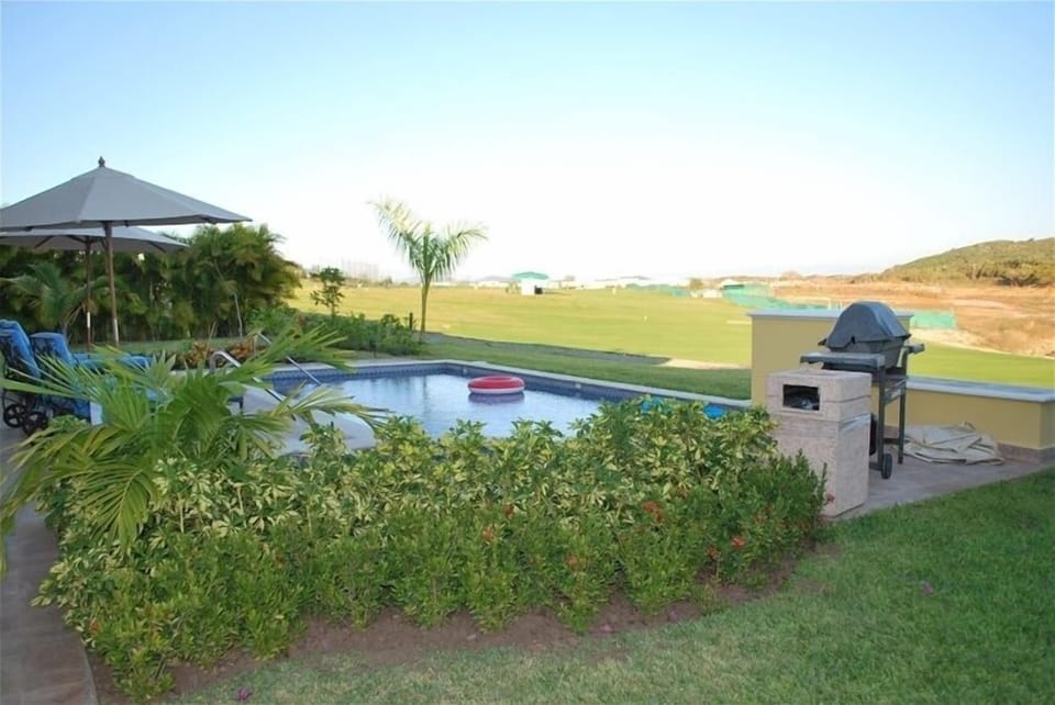 Overlooking the pool, hot tub and grill onto the golf course