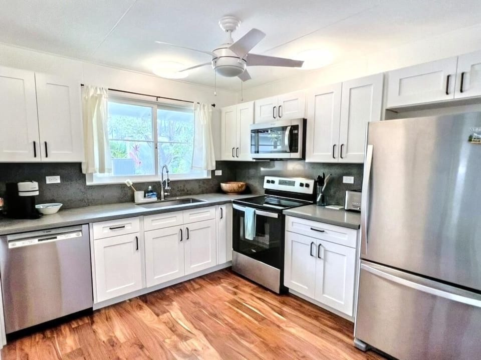 Cook with ease in the fully equipped Lanikai Cottage main house kitchen, featuring modern appliances and ample counter space.
