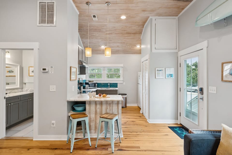 A small breakfast bar separates the kitchen and living room, with seating for 2.