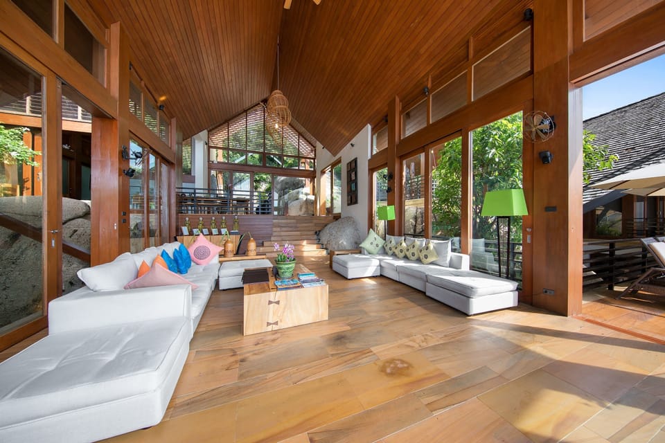 Indoor living area with folding glass walls, oversized sofas, smart TV, Apple TV