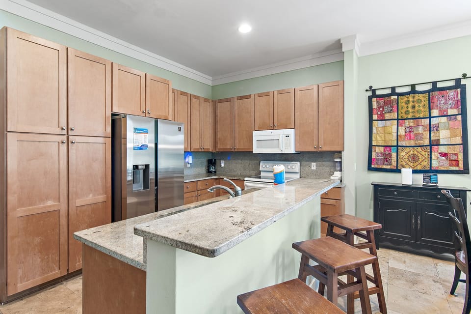 Kitchen with granite countertops, ample cabinet space, and breakfast bar seating