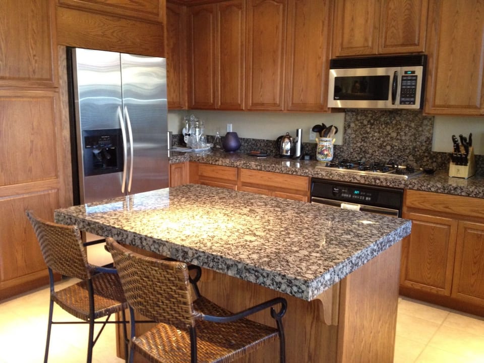 Modern, fully-equipped kitchen with granite counters and island seating