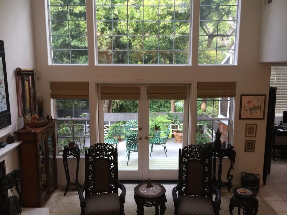 Living room with high ceilings connected to a lovely deck.