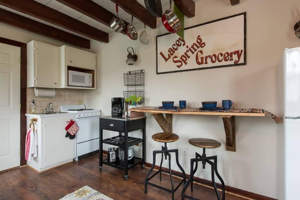 Small kitchenette for cooking with electric stove, refrigerator, and sink