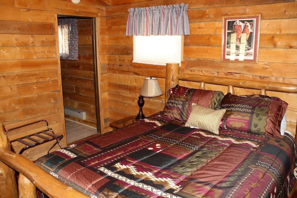 Bedroom with queen bed.  Door leads to bathroom with shower stall.