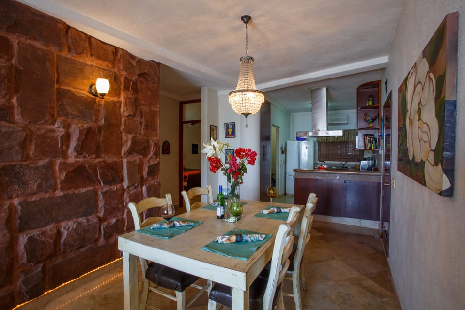 Dining area looking towards the kitchen. Master bedroom past rock wall.
