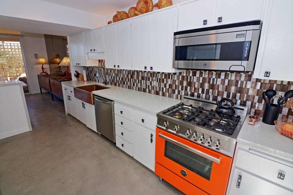 Kitchen features orange Italian Bertazzoni range and microwave