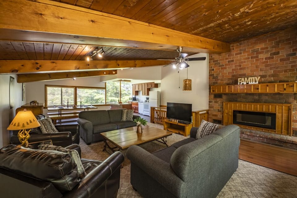 Open concept upper level with dining/sitting areas, smart TV, fireplace, kitchen